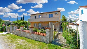 A two-story house with a stone wall, a metal gate, and a clear blue sky. - Apartment 1838/21894 (Istria - Pomer), 400m from the beach (Pomer)