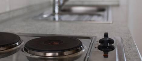 A kitchen with a gas stove, a sink, and a faucet.