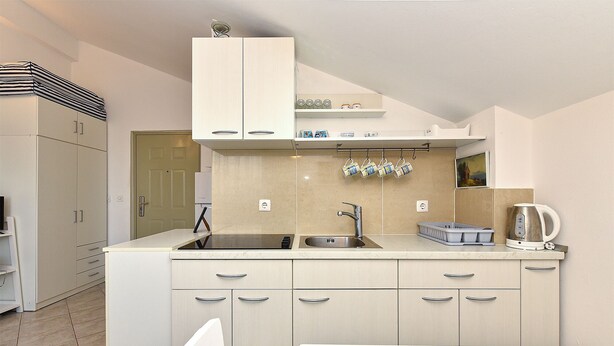 A modern kitchen with light-colored cabinets, a double sink, and a kettle on the countertop. - Apartment 1860/22683 (Istria - Medulin), 1500m from the beach (Medulin)