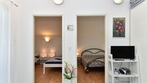 A hotel room with a bed, bedside table, lamp, and a TV on a stand. - Apartment 1860/22683 (Istria - Medulin), 1500m from the beach (Medulin)