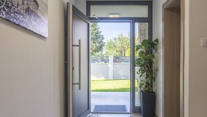 A hallway with a glass door leading outside, a potted plant, and a wall-mounted artwork. - Villa 1863/22758 (Istria - Poreč), 350m from the beach (Poreč)
