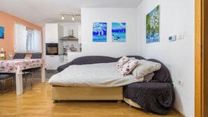 A bedroom with a bed, a dining area with a table and chairs, and a kitchen in the background. - Apartment 1873/23021 (Istria - Pula), 3000m from the beach (Pula)