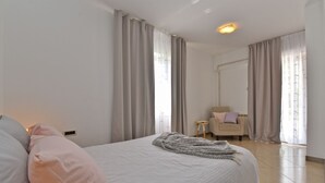 A bedroom with a bed, a chair, and a small table.