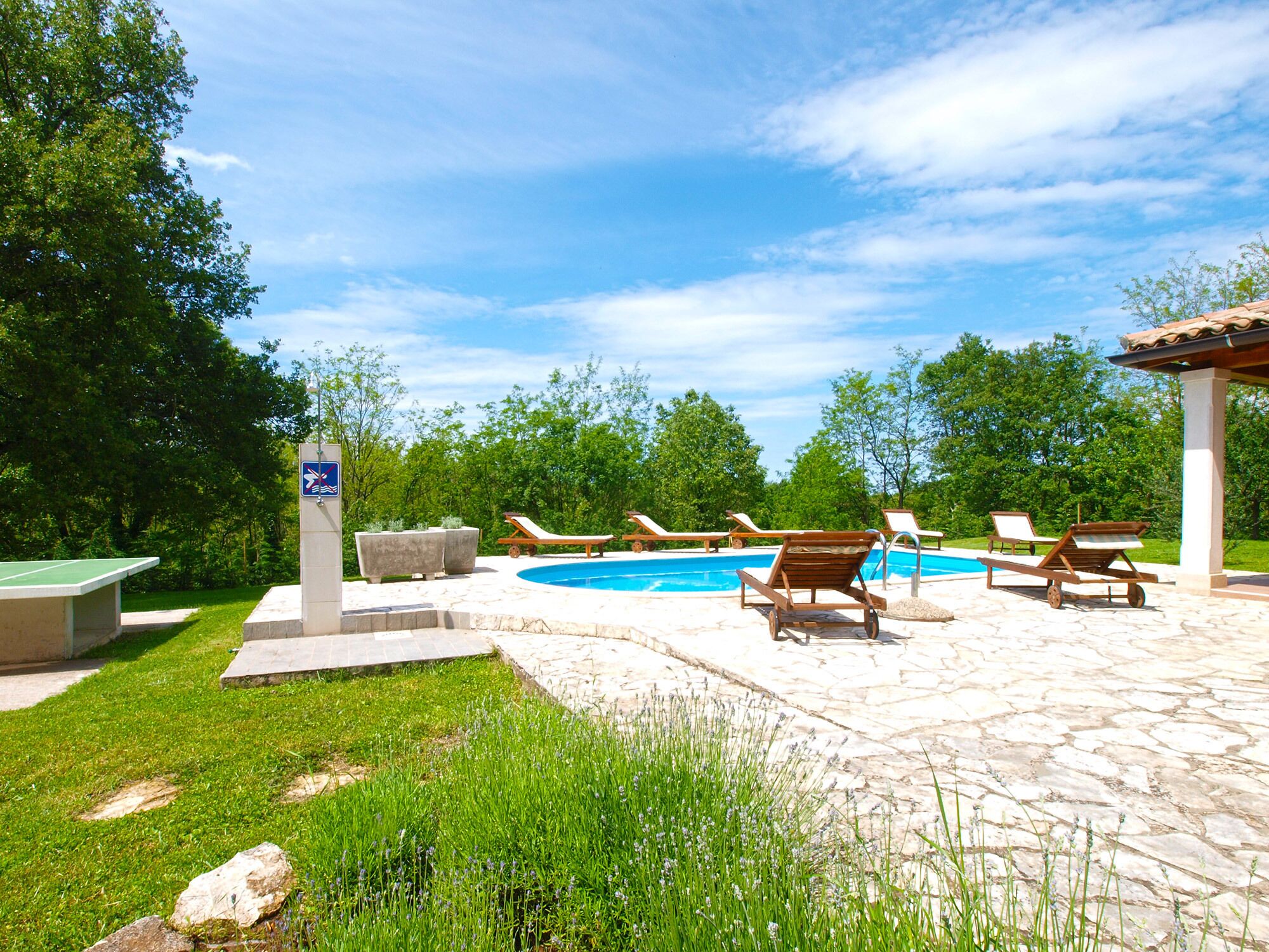 Un área de piscina con sillas de descanso y un letrero que indica una zona para nadar.