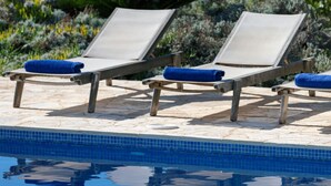 A poolside area with lounge chairs and a view of the ocean. - Steps from the Beach, Sunset Views to Remember! (Chania)