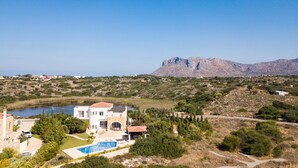 A large house with a swimming pool, surrounded by greenery and a mountain in the background. - Steps from the Beach, Sunset Views to Remember! (Chania)