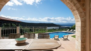 A patio with a pool, outdoor seating, and a view of the landscape. - Steps from the Beach, Sunset Views to Remember! (Chania)