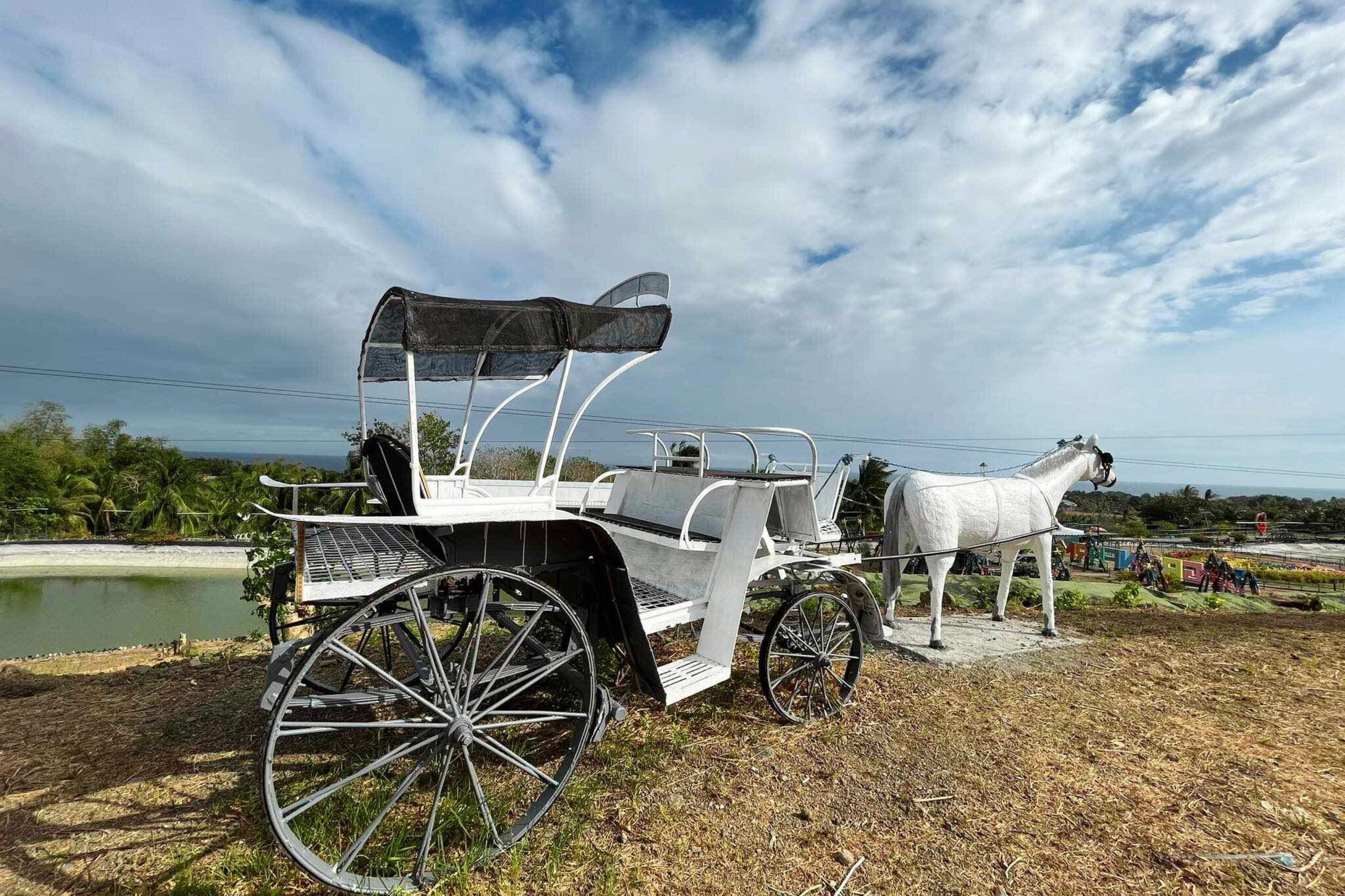 Un carruaje tirado por caballos con dosel y una estatua de un caballo.