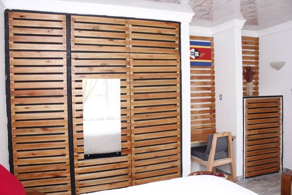 A room with a wooden sliding door, a small window, and a chair.