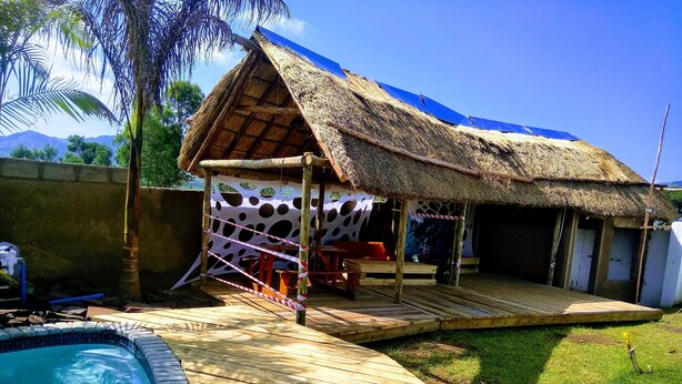 A thatched-roof structure with a pool, wooden deck, and a covered seating area. - Lawu Le Ngwenya Guest House (Motshane)