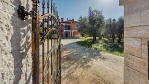 A rustic gate leading to a stone building with a gravel driveway and olive trees. - Apartment 1899/23273 (Istria - Rovinj), 1000m from the beach (Rovinj)