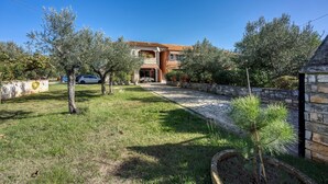 A stone house with a tiled roof, surrounded by a stone wall and a grassy yard. - Apartment 1899/23273 (Istria - Rovinj), 1000m from the beach (Rovinj)