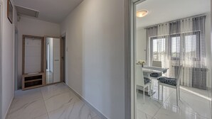 A hallway with a mirrored wall, a door leading to a balcony, and a view of the outside through sheer curtains. - Apartment 1899/23274 (Istria - Rovinj), 1000m from the beach (Rovinj)