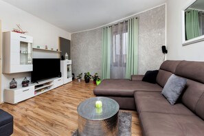 Relax in this stylish living room with a flat-screen TV, comfortable sofa, and cozy coffee table.