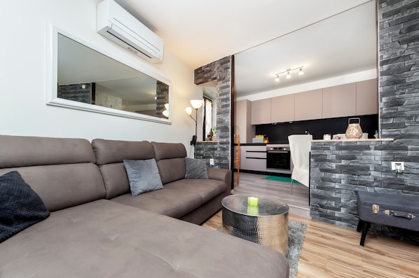 Relax in this inviting space with a modern sofa, round coffee table, and sleek kitchen area.