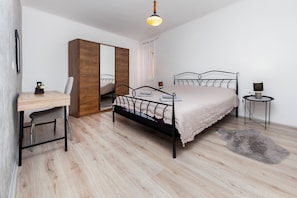 Enjoy a restful stay in this stylishly designed room with a neatly arranged bed, desk, and mirror.