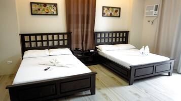 A hotel room with two beds, a brown curtain, and two wall-mounted air conditioning units.