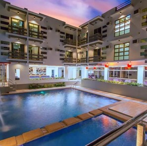 A modern building with multiple balconies and a swimming pool. - The Mang-Yan Grand Hotel powered by Cocotel (Puerto Galera)