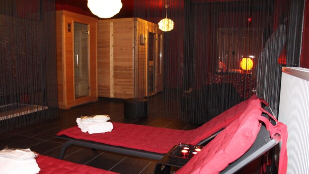 A sauna room with two massage tables, towels, and candles. - B & B Aphrodite (Zonnebeke)