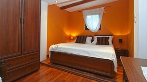 Una camera da letto con un letto di legno, un armadio e una finestra con tenda leggera.