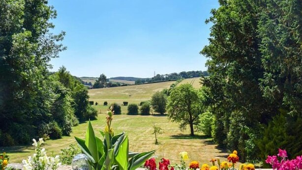 A rural landscape with a clear sky, rolling hills, and a variety of trees and shrubs. - Turpins Ride (Chalfont St Giles)