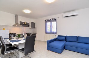 A compact living space with a kitchenette, a dining area, and a blue sofa. - Apartment 1938/23982 (Istria - Vodnjan), 4500m from the beach (Vodnjan)