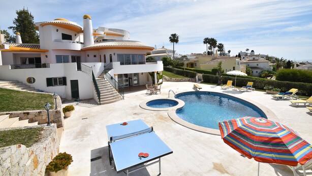 A modern house with a swimming pool, outdoor seating, and a staircase leading to the upper floors. - Villa Atlantida, a charming hillside villa with a fabulous pool, great sea view. (Albufeira)