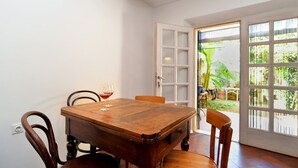 A dining area with a wooden table and chairs, a wine glass, and a view through a glass door to a garden. - House 1953/24881 (Istria - Vodnjan), 6000m from the beach (Vodnjan)