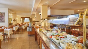 Un espace buffet avec plusieurs tables et une grande variété de plats proposés.