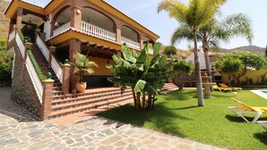 A two-story house with a balcony, a stone staircase, and a well-maintained lawn. - 1128 Villa AndreaSol (Frigiliana)