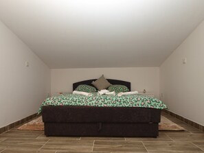 Ein Schlafzimmer mit einem Bett, einem Nachttisch und einer wandmontierten Lampe.