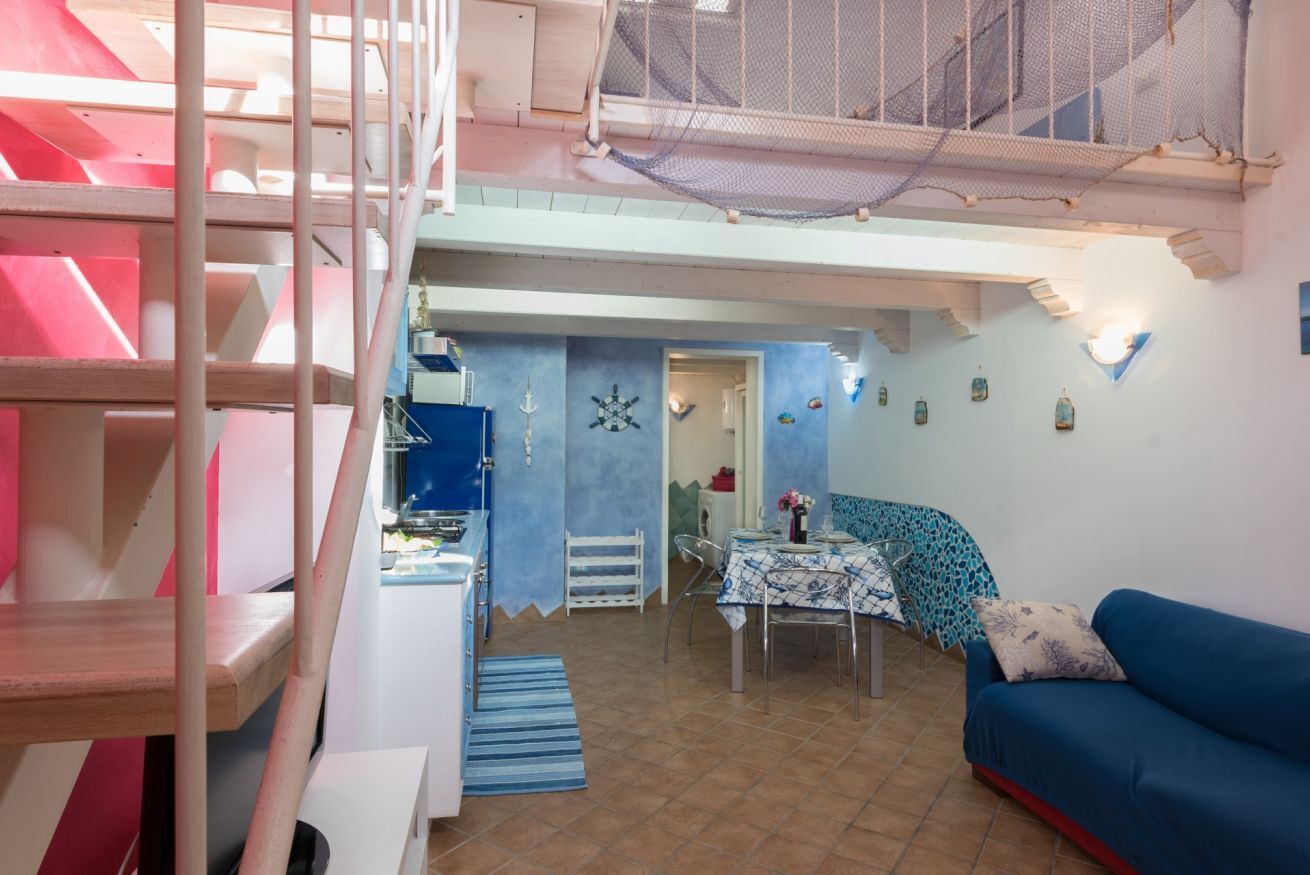 A multi-level interior with a staircase, a dining area, and a living space.