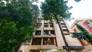 Un edificio de varios pisos con un letrero que dice 'NEERANAND PLAZA'.