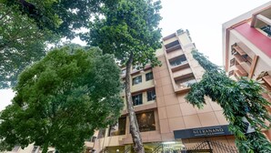 Un edificio de varios pisos con un letrero que dice "NEERANAND PLAZA".