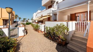 A residential street with houses, a bicycle, and a gate. - I Tre Golfi Faro Blu Apartment (San Vito Lo Capo)