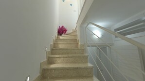 Eine Treppe mit Handlauf und einer Blumenvase am oberen Ende.