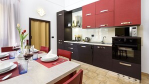 Una cucina moderna con mobili rossi, un forno a microonde e un fornello.