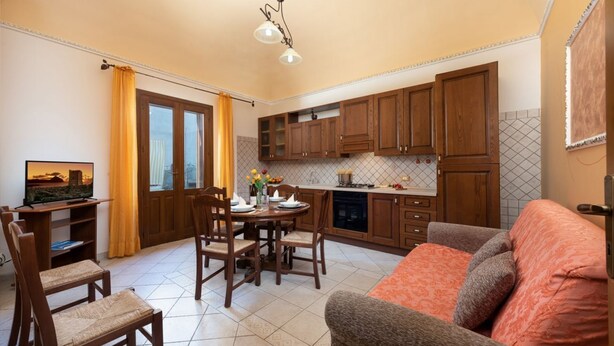 A compact living space with a dining area, kitchen, and seating area. - I Tre Golfi Luna Turca Apartment (San Vito Lo Capo)
