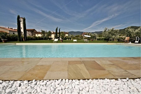 Una piscina al aire libre de temporada, sombrillas