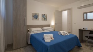 Ein Hotelzimmer mit einem Bett, einem Schreibtisch und zwei Wandbildern.