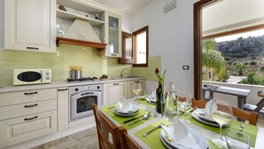 Eine moderne Küche mit Essbereich, ausgestattet mit Mikrowelle, Herd und Backofen.