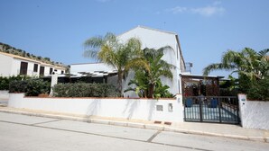 A modern house with a white facade, a gated entrance, and a small patio area with plants. - I Tre Golfi Villa Iride (San Vito Lo Capo)