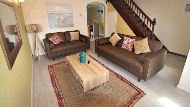 A living room with two brown sofas, a coffee table, and a colorful rug. - DO NOT USE (Doncaster)