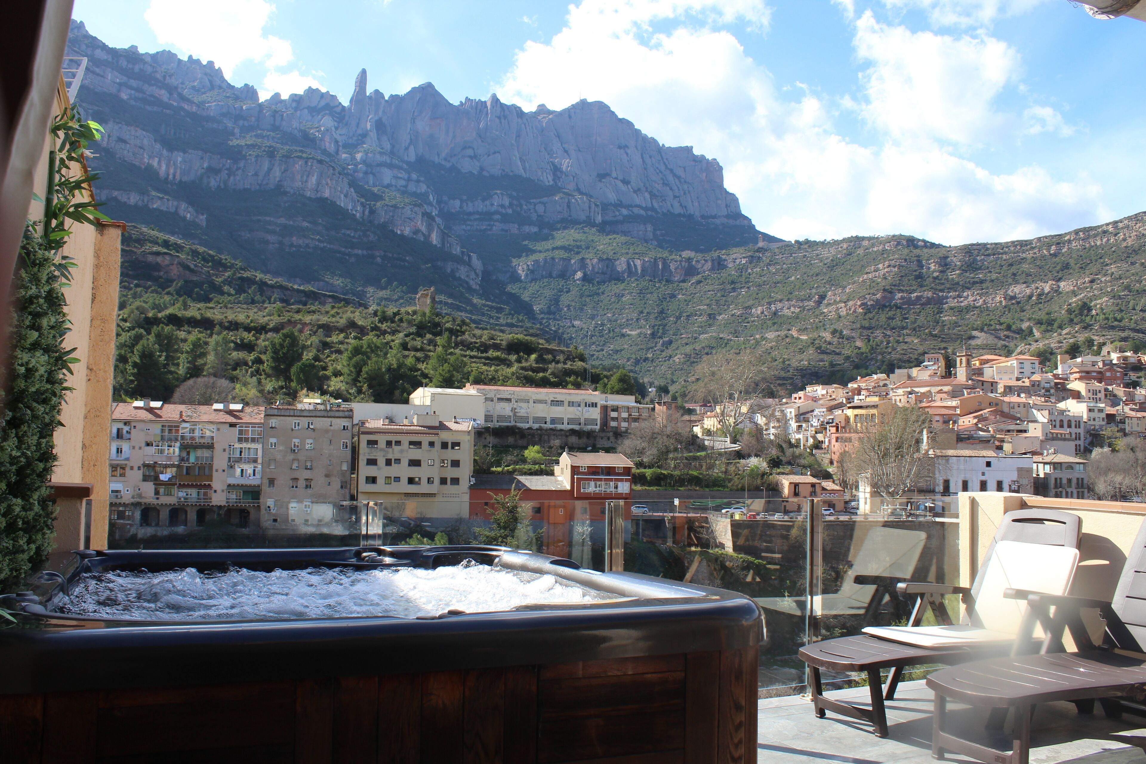 A hot tub with a view of a mountainous town.
