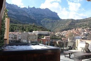A hot tub with a view of a mountainous town.