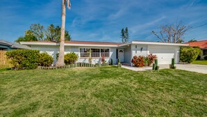 A single-story house with a red roof, white exterior walls, and a front garage. - 5 O'clock Somewhere - Private Elec. Heated Pool - WIFI - Streaming TV - BBQ (Cape Coral)