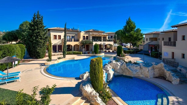 A resort with a large swimming pool, multiple buildings, and well-maintained landscaping.
