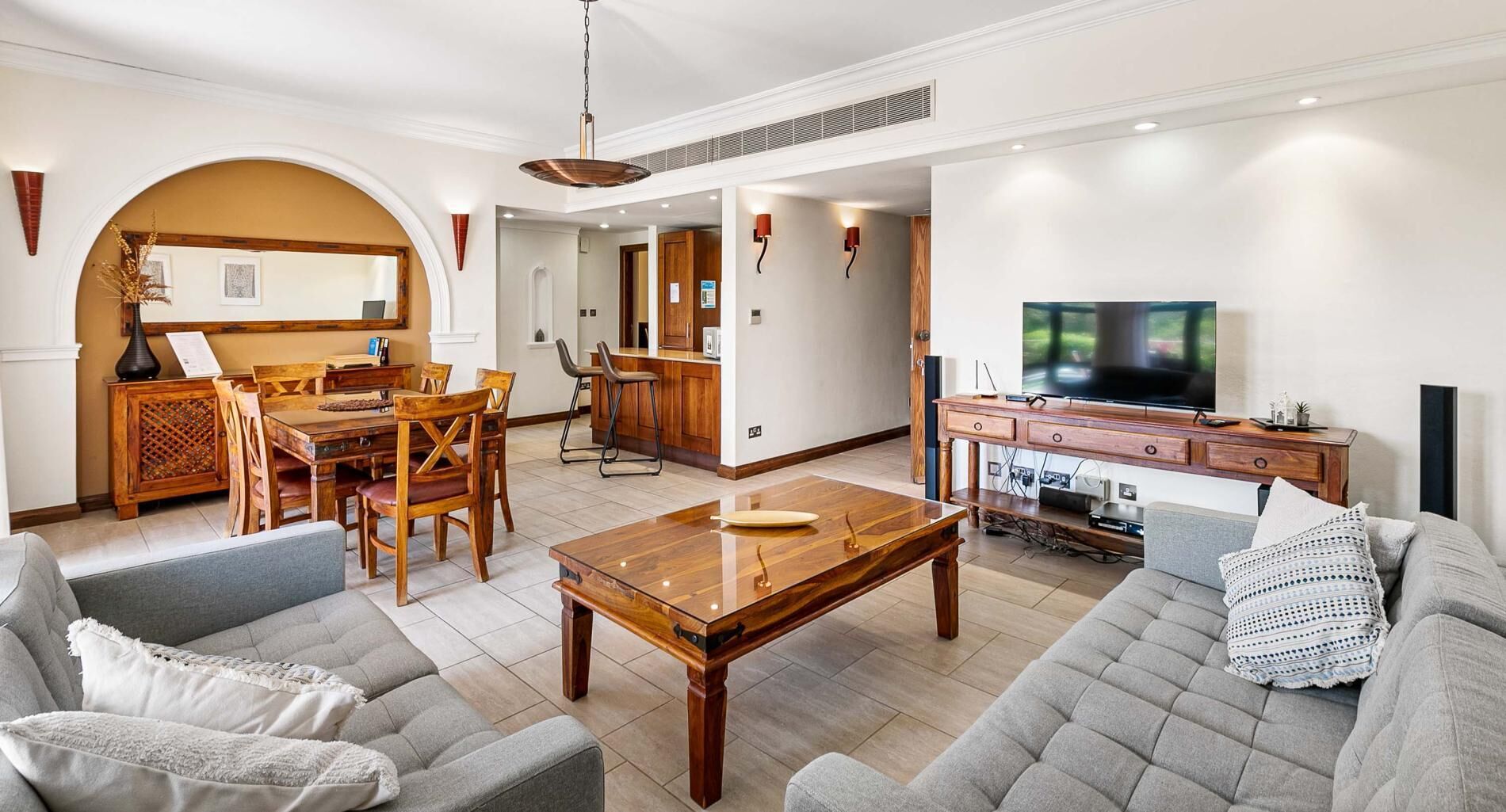 En moderne stue med sofa, sofabord og spiseområde.