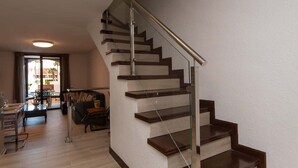 A modern living room with a staircase leading to an upper floor. - Parque Santiago II 85 - Two Bed south facing (Playa de la Américas)