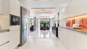 Una cocina moderna con una isla central, electrodomésticos integrados y vistas a un patio exterior.